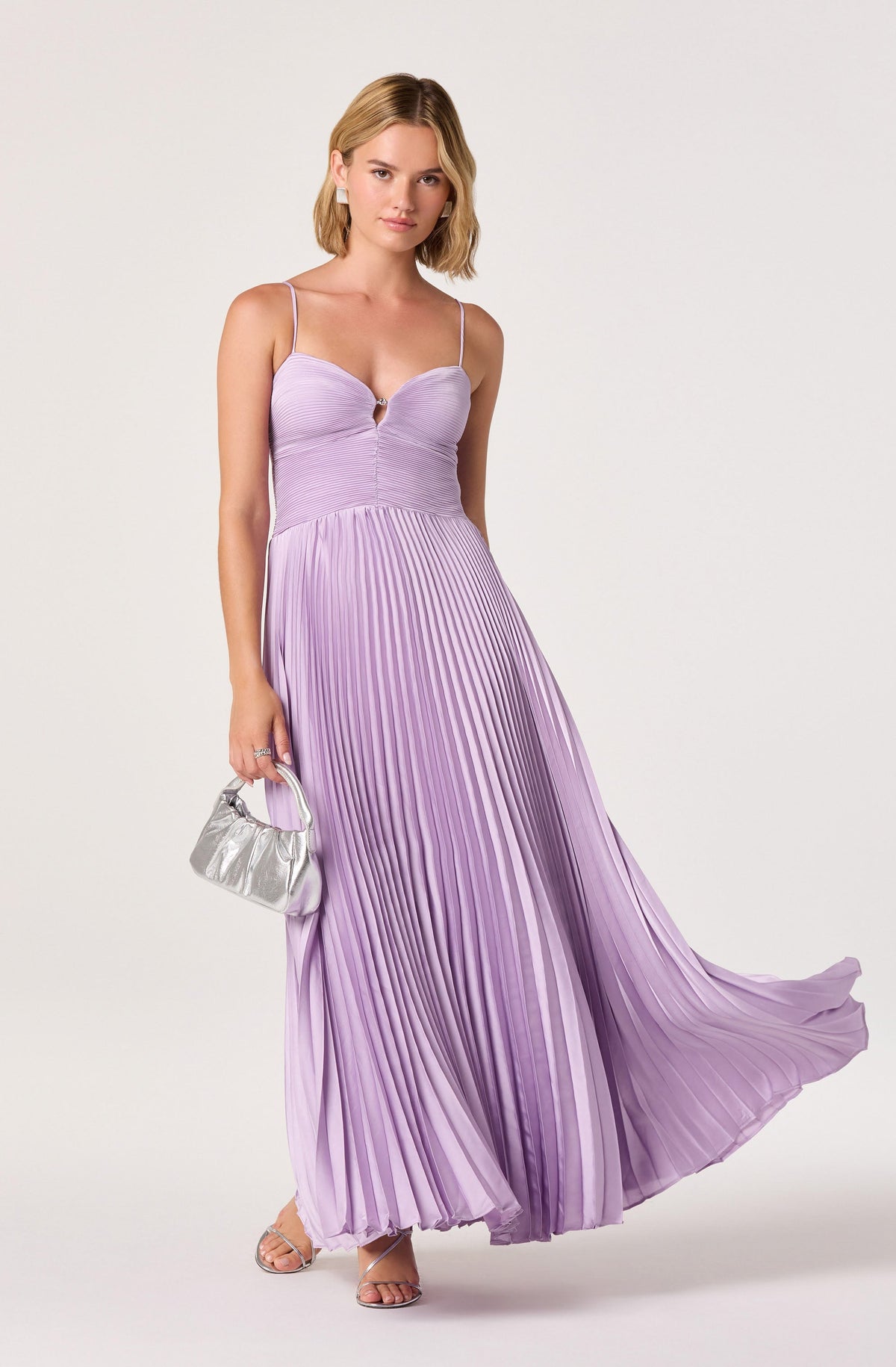 Women wearing a lavender pleated maxi dress with spaghetti straps and a cut-out detail at the bust.