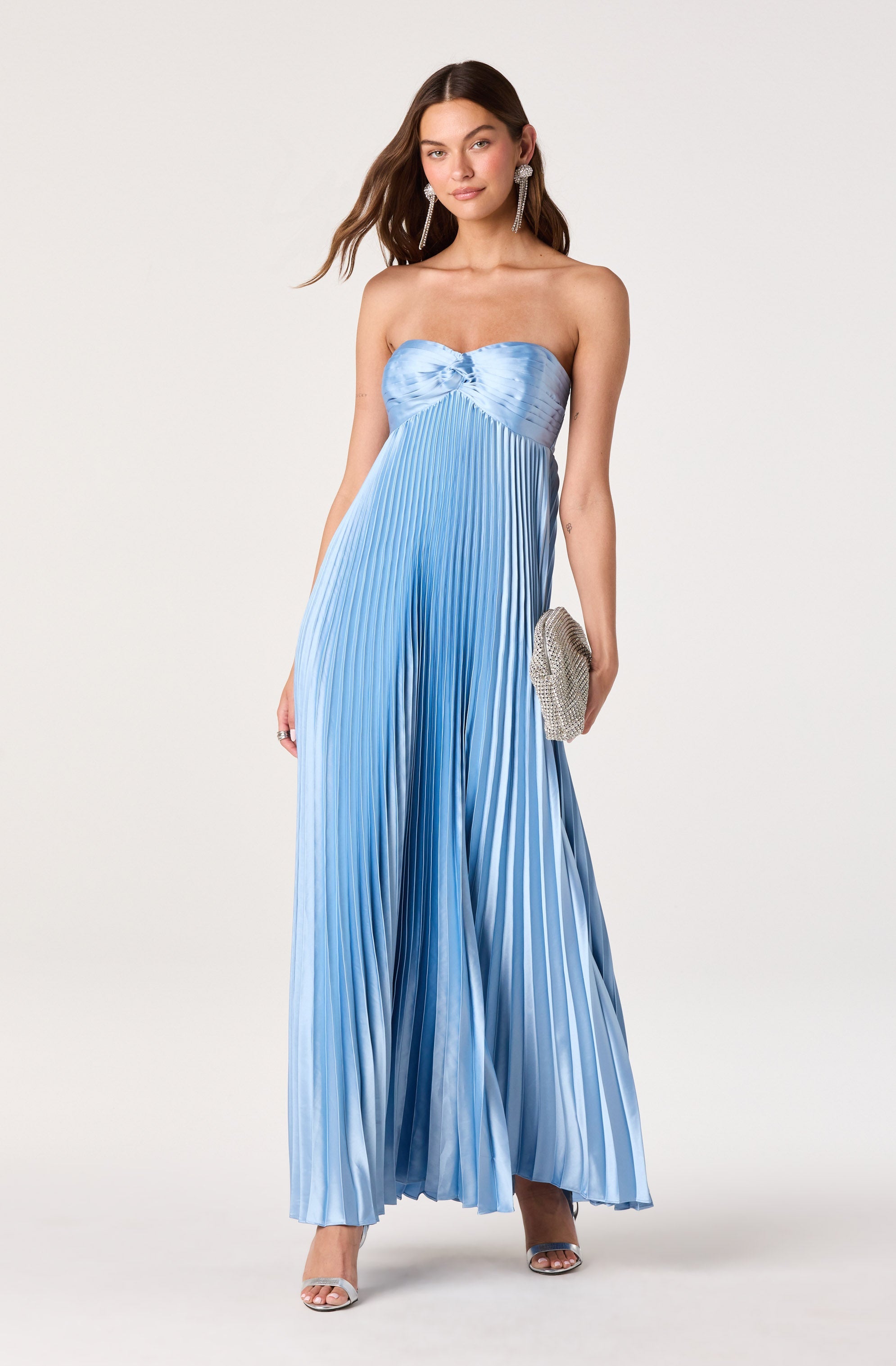 Woman in a strapless, light blue, pleated maxi dress with a satin bodice.