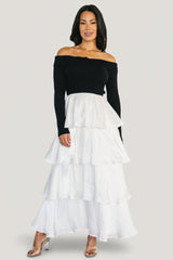 Front view of Maelie Tiered Maxi Dress on model; black ribbed off-shoulder sweater bodice with white tiered satin maxi skirt, full length.