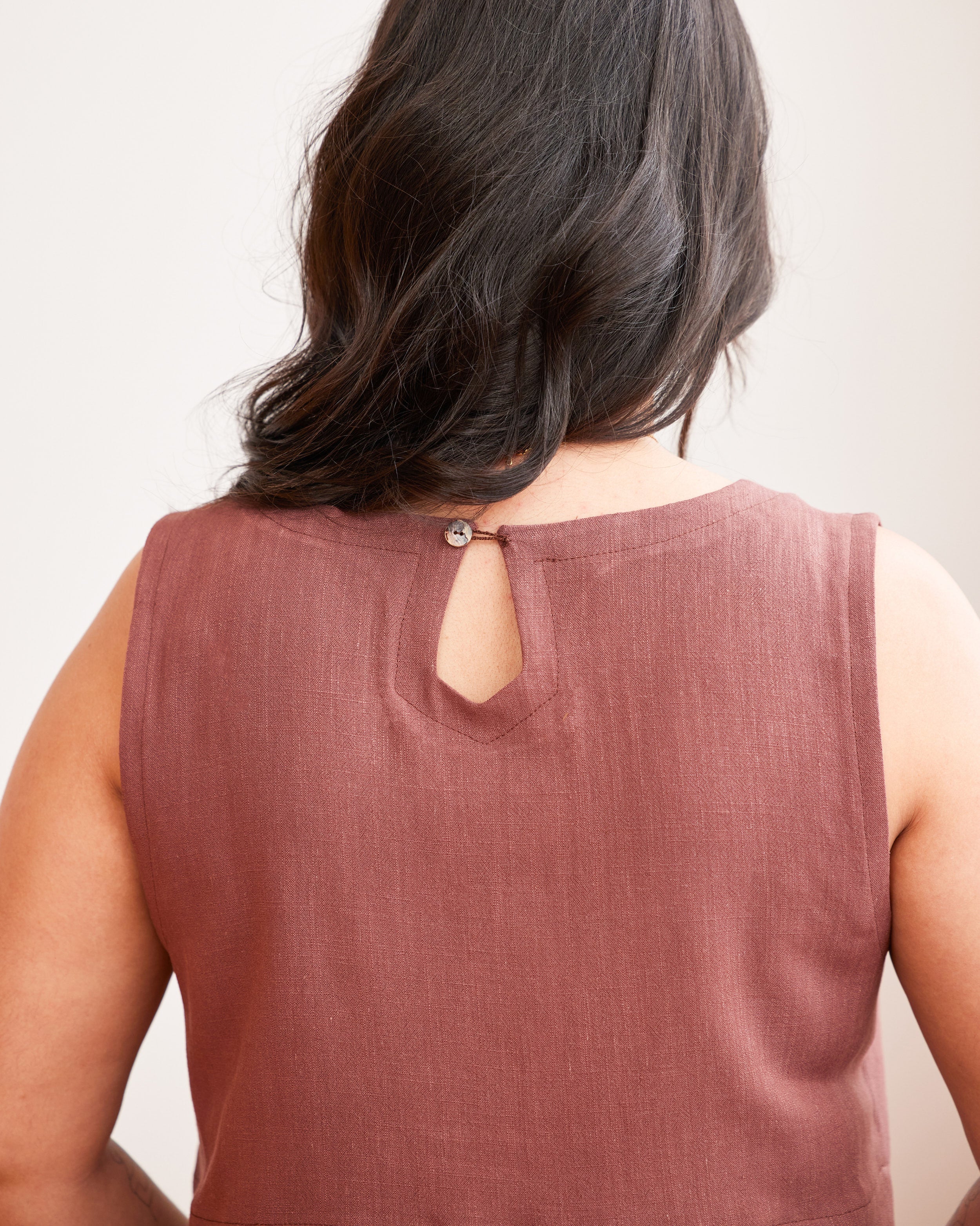 Brown sleeveless top worn by a person with a plain background. This top is the Thorndike Tank sewing pattern from Cashmerette.