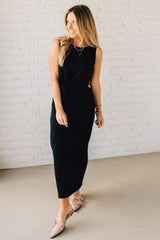 Blonde Woman Wearing a Black Maxi Length Pencil Dress with Side Cut Out on the Left.