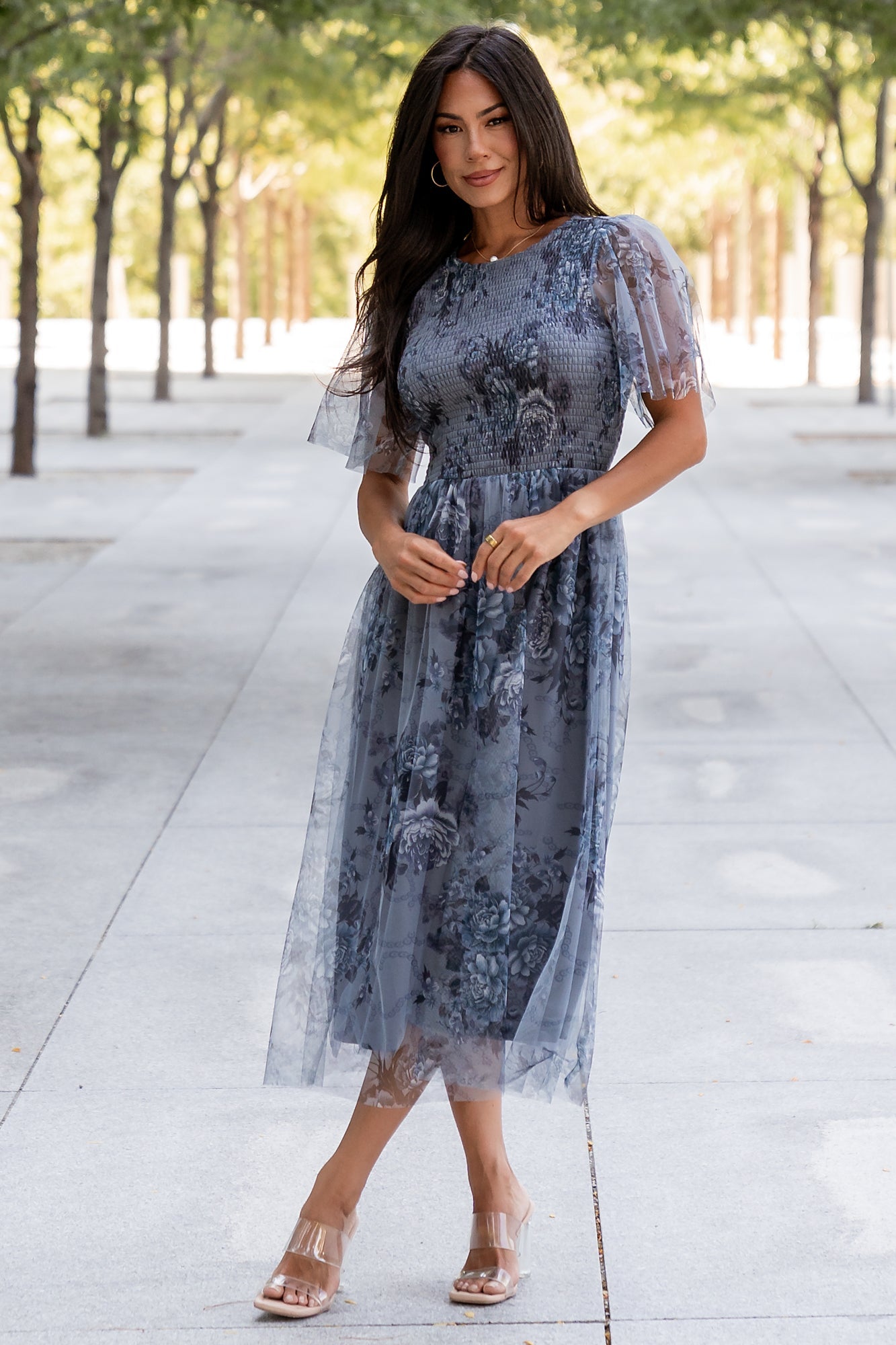 Front view of Josie Tulle Midi Dress in dusty blue floral, showing smocked bodice, short sleeves, and soft layered tulle overlay in full length.