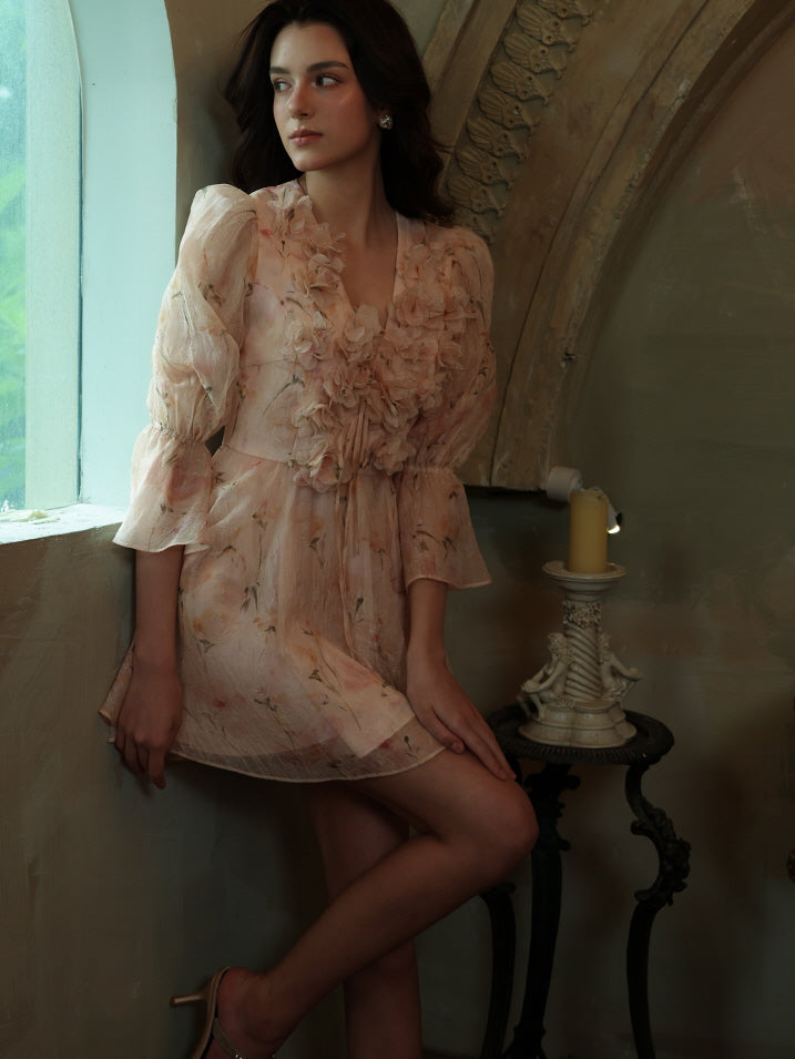 A young woman stands by a sunlit window in a dreamy fairycore-inspired mini dress with floral texture and soft puff sleeves, gazing thoughtfully outside.