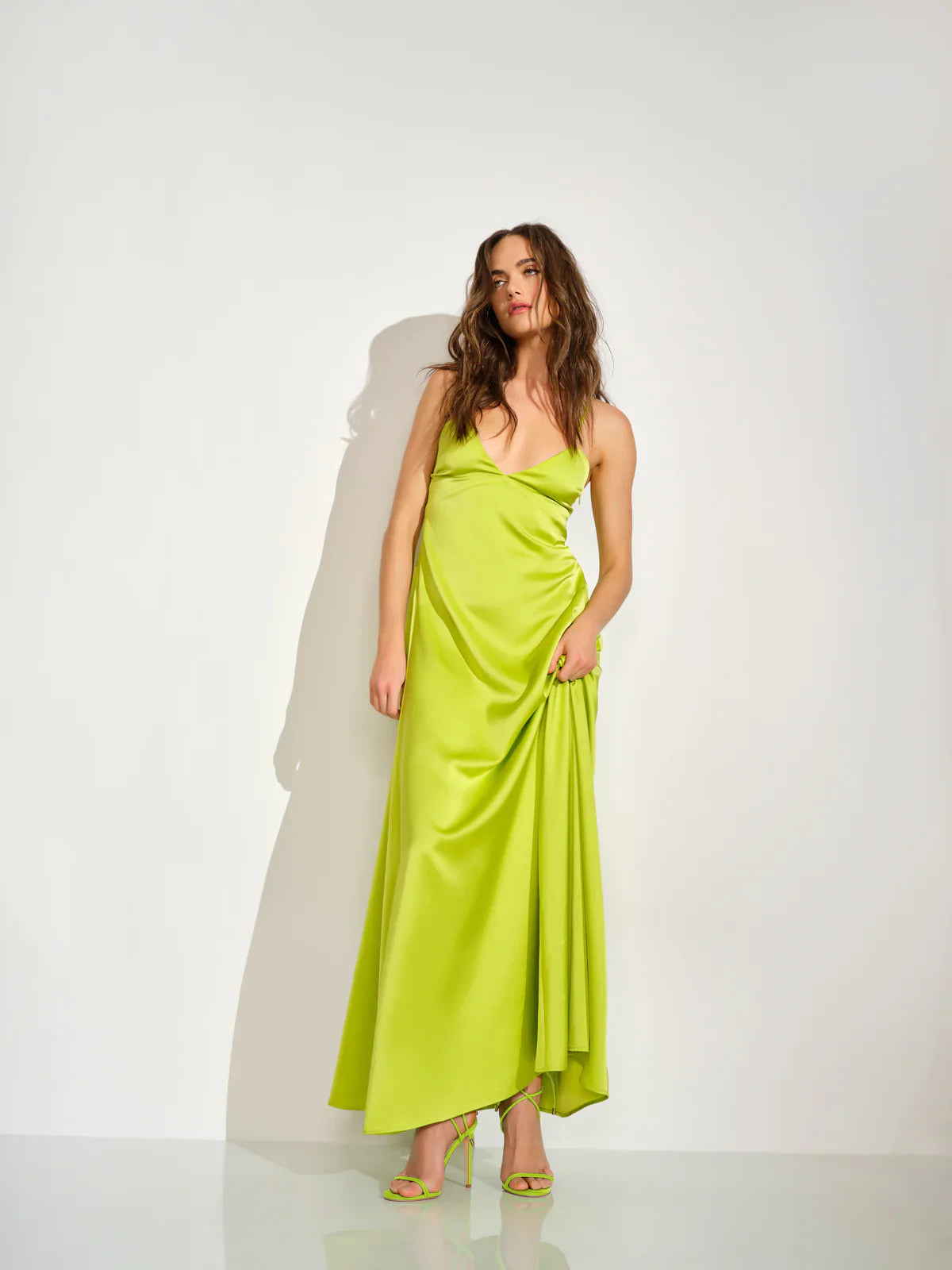 Woman wearing a bright green dress against a white background