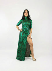 Woman in an emerald green mesh turtleneck dress with 3/4 sleeves and a thigh-high slit, standing in heels against a white background.