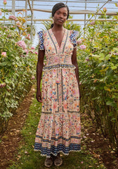 Superbloom Tapestry Maxi Dress by Farm Rio, model wearing a floral maxi dress in a garden setting.