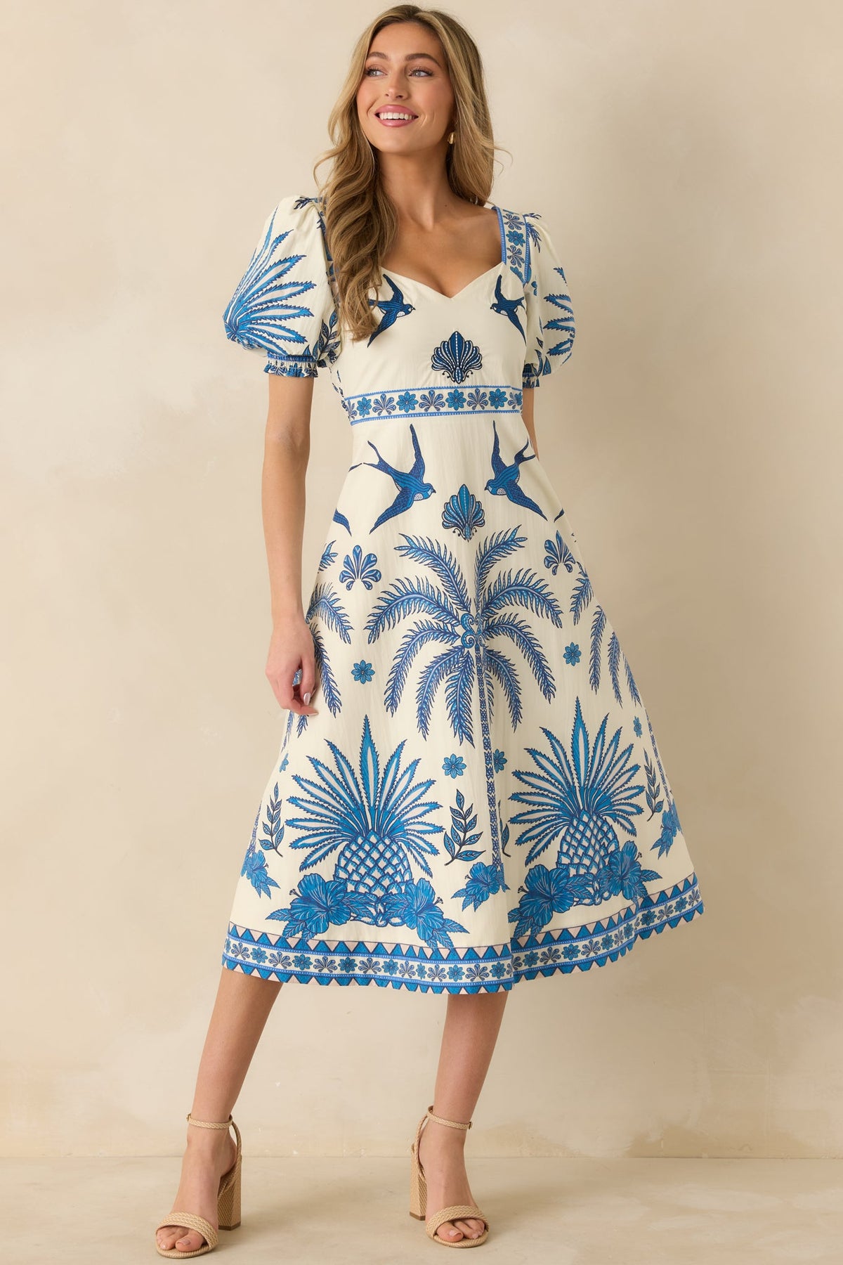 Full front view of blue and ivory midi dress with tropical print and sweetheart neckline.