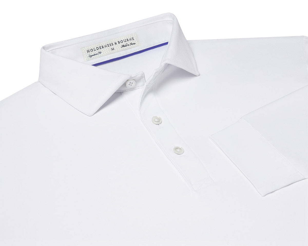 The Farrell Shirt: White, featuring a polo-style button-front, spread collar, two buttons, sleeve cuff, and the “Holderness & Bourne” label, showcasing performance fabric.