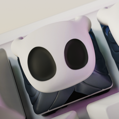 Angled shot of Hollow Knight artisan keycaps installed on a keyboard, highlighting their expressive ghost faces.
