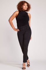Woman wearing soft faux suede high-waisted leggings with stretchy fit, luxurious texture, versatile neutral bottoms for day-to-night style