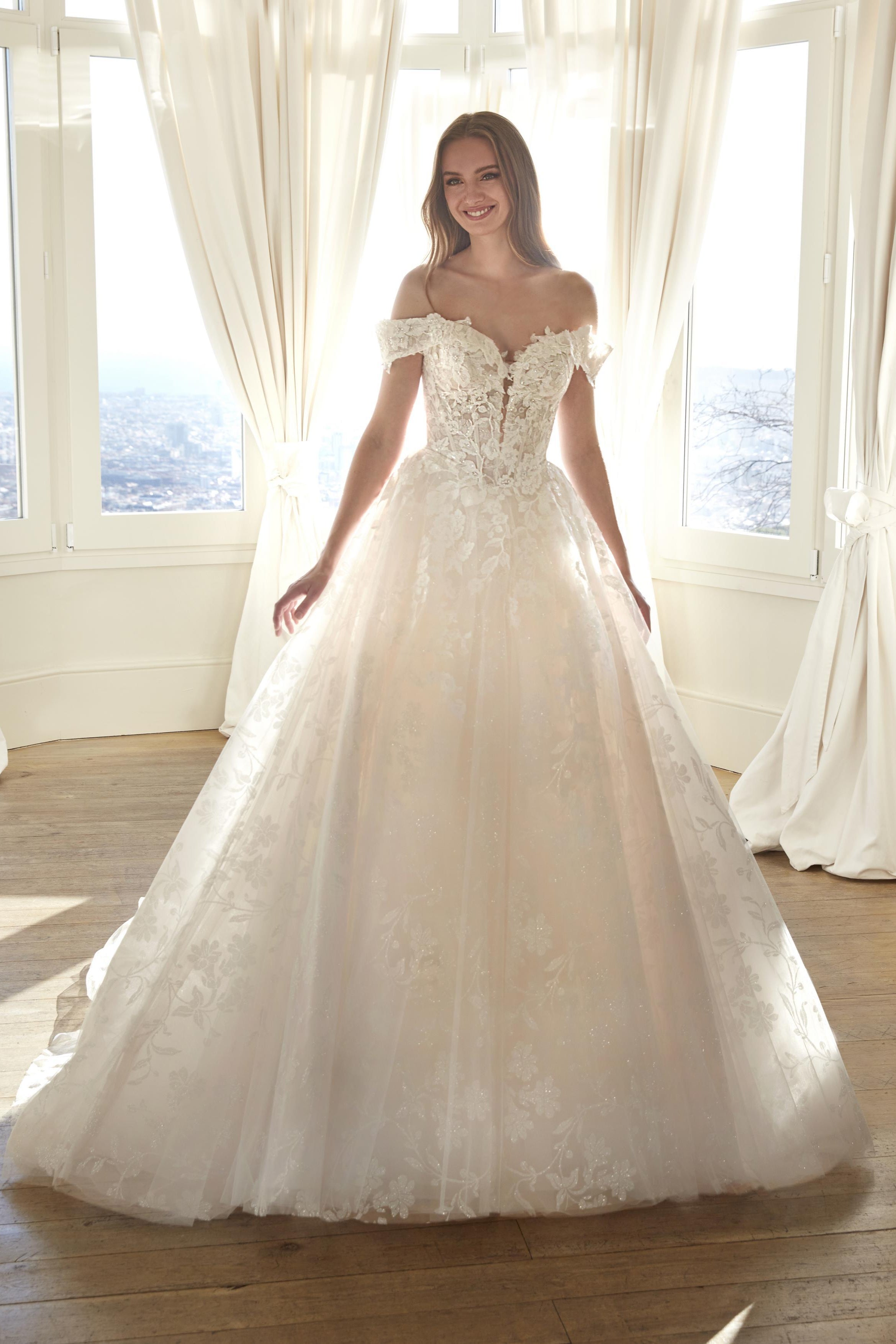 Front view of the Juddy sparkly princess wedding dress featuring off-the-shoulder floral straps, a subtle drop waist, and a glitter tulle skirt.