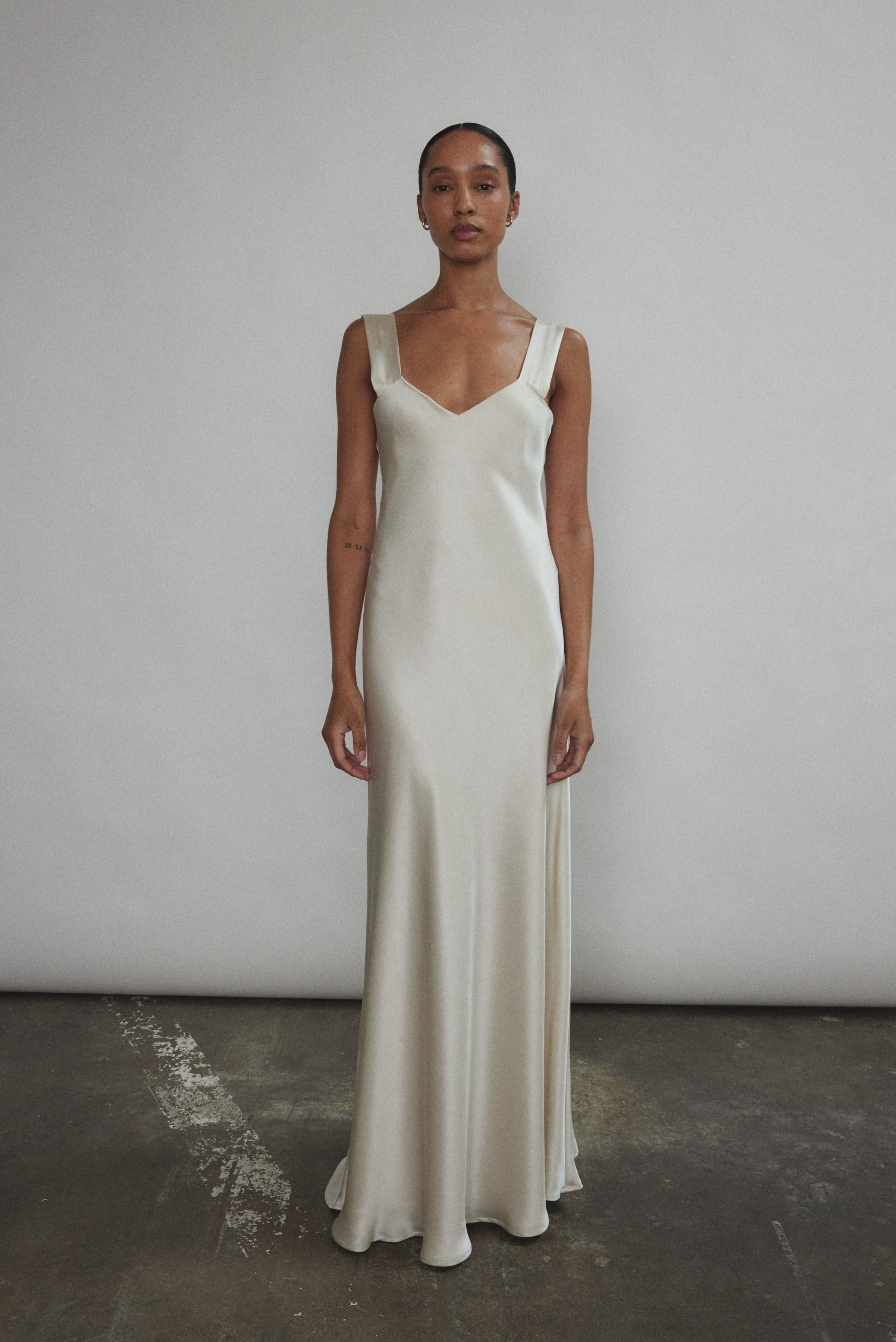 Front view of a model wearing the ivory silk charmeuse Kamperett Lisette Maxi Slip Dress, a bias-cut V-neck minimalist wedding slip.