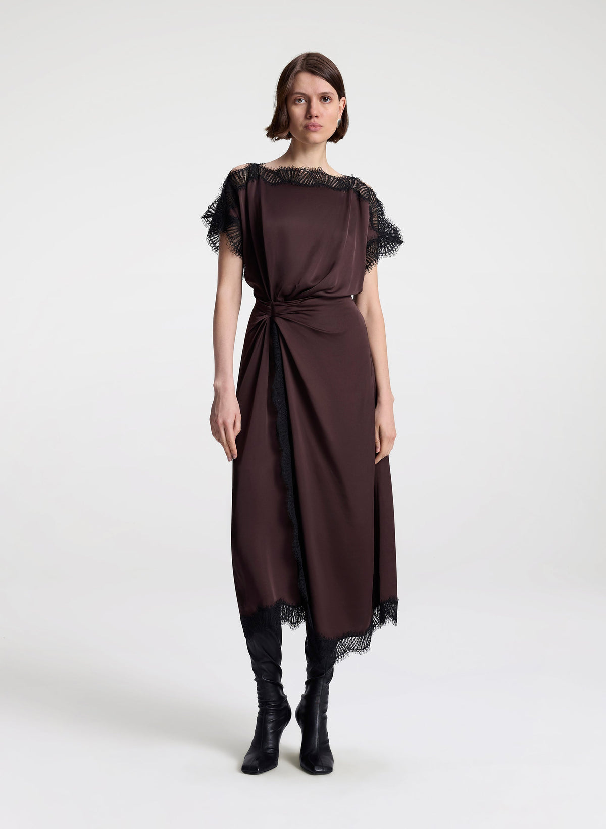 Woman wearing a brown dress with lace details on a white background
