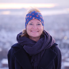 Bilde av dame med blå lue med brune prikker og pelsdusk. 