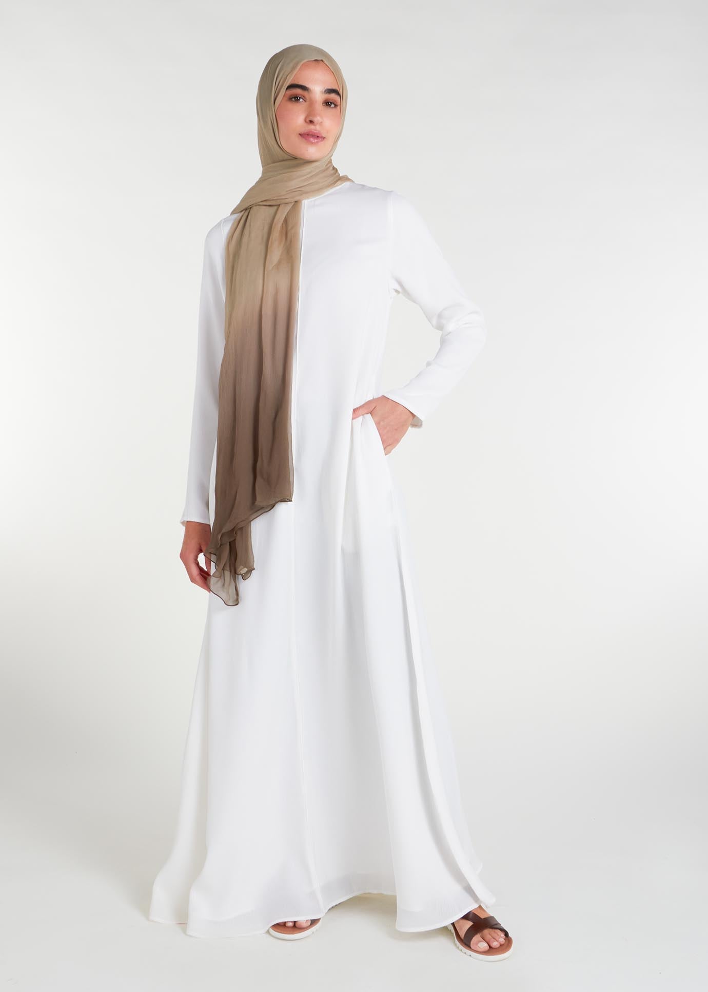 Long Line Abaya in Classic White, featuring a flattering silhouette that effortlessly complements your style. Experience comfort and sophistication in every step with this must-have addition to your modest collection.