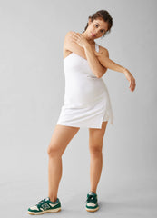 ||Pregnant woman wearing a white active dress on a gray background