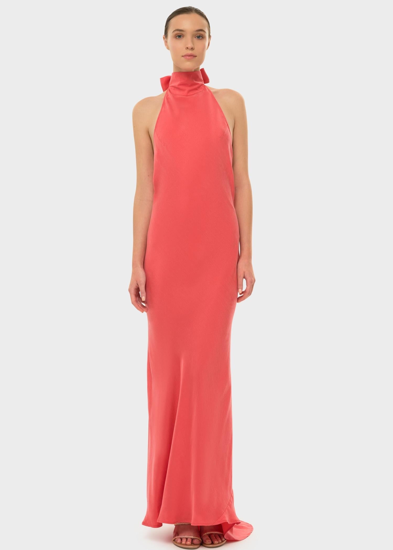 Woman in a coral halter maxi dress.