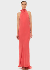 Woman in a coral halter maxi dress.