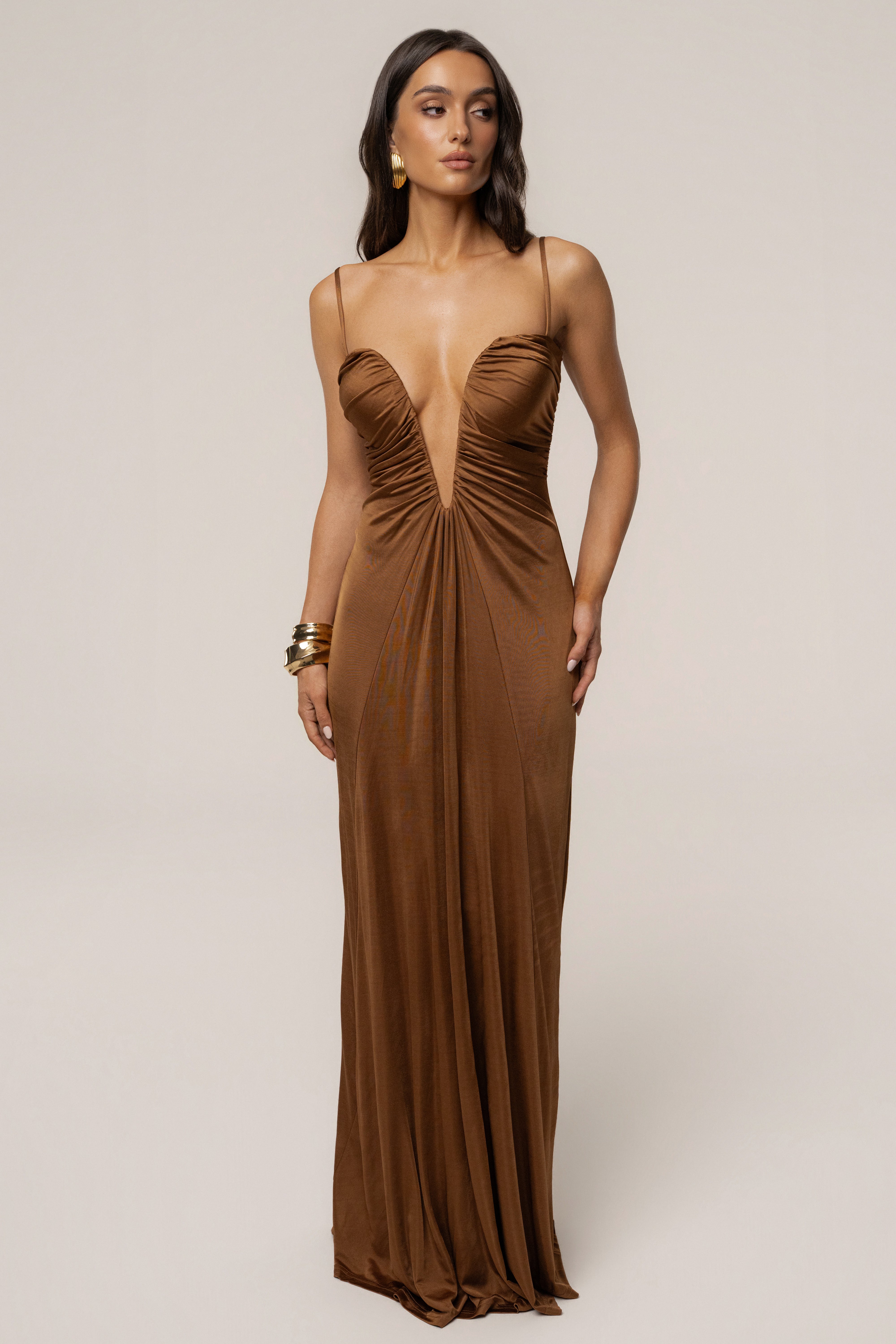 Tan Auric deep plunge maxi dress by JLUXLABEL, featuring a flowing silhouette and plunging neckline, displayed on a model.