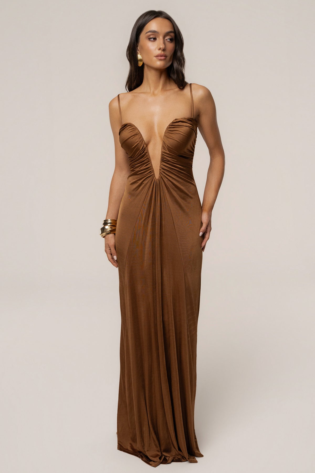 Tan Auric deep plunge maxi dress by JLUXLABEL, featuring a flowing silhouette and plunging neckline, displayed on a model.