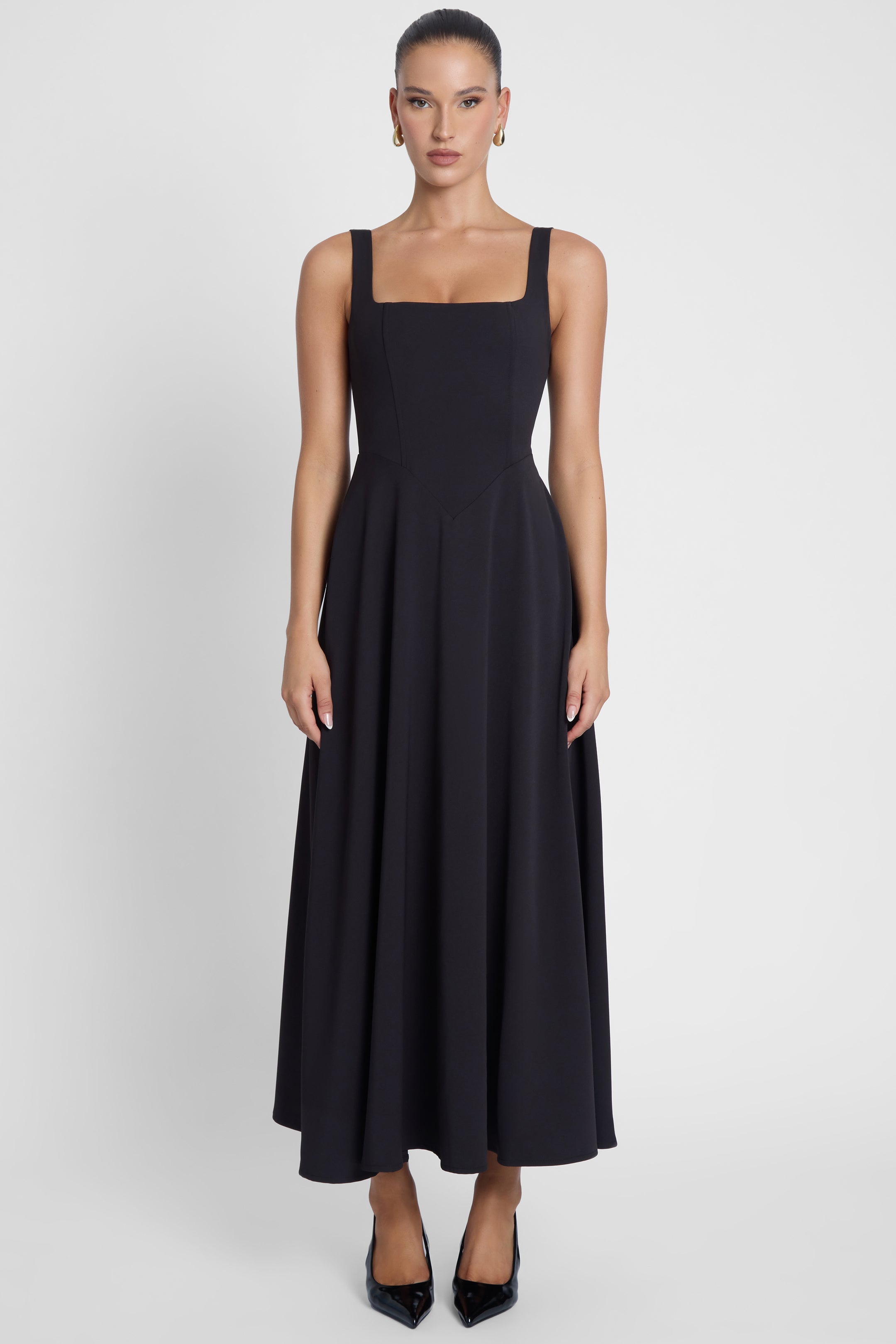 Model is wearing Serenity Square Neck Corset Midi Dress Black, front view.