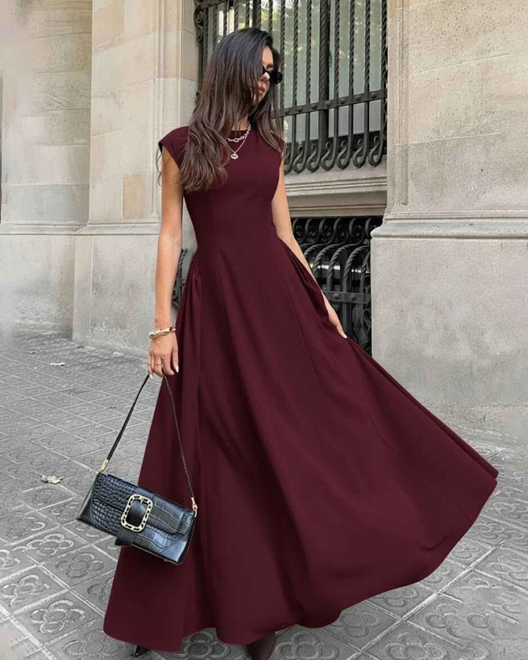 Front view of Solid burgundy crew neck fit and flare maxi dress with fitted bodice and elegant flowing skirt silhouette