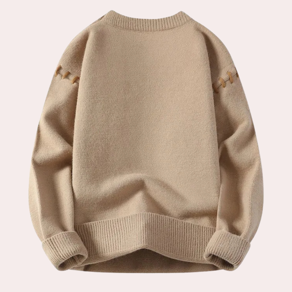Beige ullgenser med ribbestrikkede kanter og dekorative sømmer på skuldrene, perfekt for høst- og vintermote. Komfortabel og stilren design.