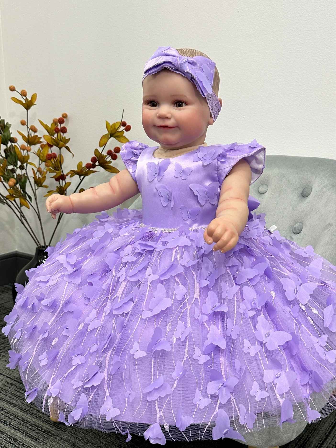 Baby in a purple dress with a matching headband for a special occasion.