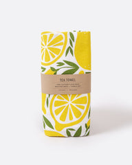 A tea towel with a lemon pattern. Shown folded in its paper wrapping.