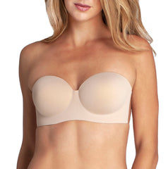 Model stands wearing the Voluptuous Backless Strapless Bra. It lifts and shapes without straps, and is perfect for larger busts. Bra is nude in color.