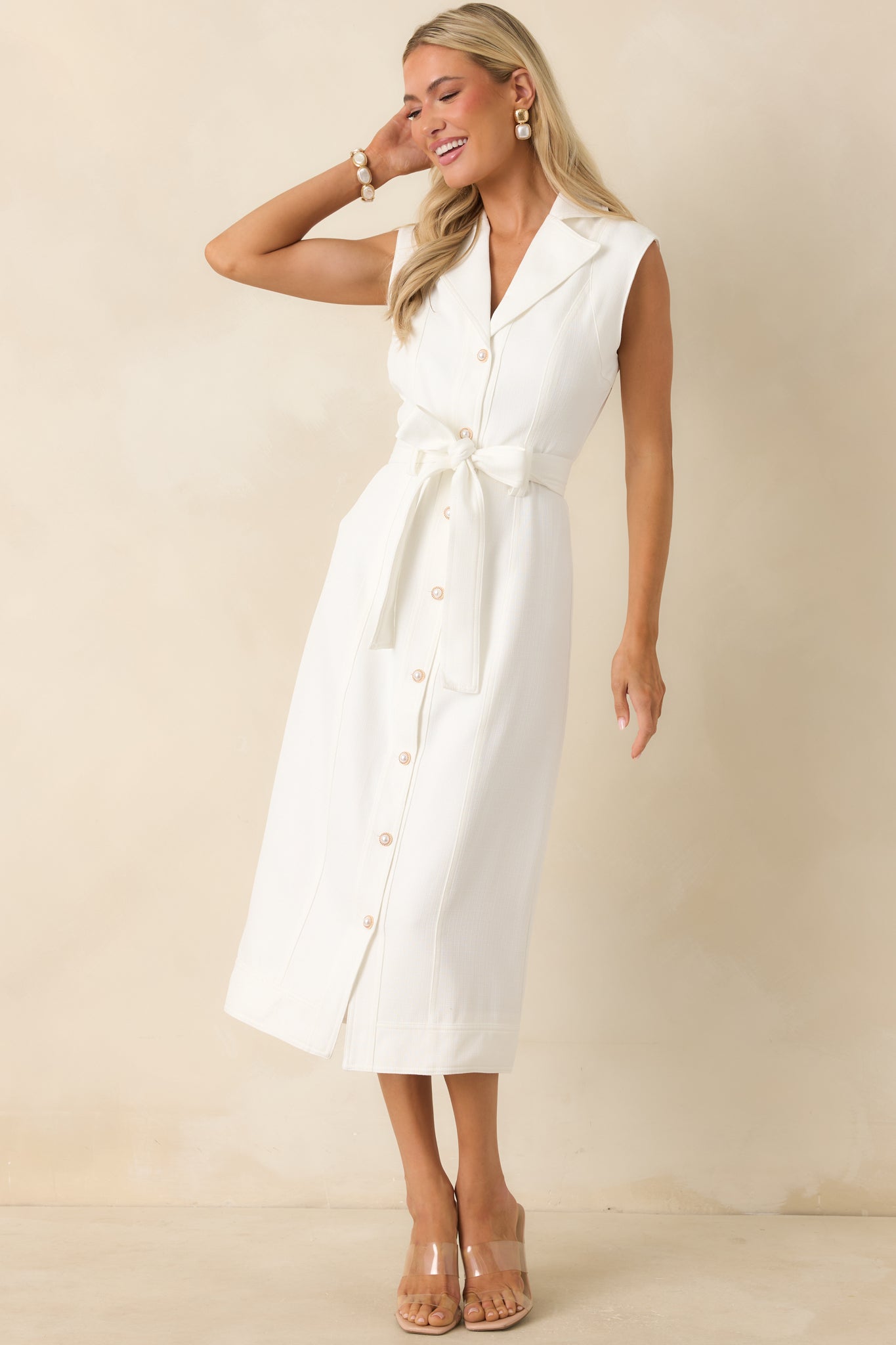 Full-length view of a white midi dress featuring a collared neckline, functional button front, cap sleeves, and an optional self-tie belt.