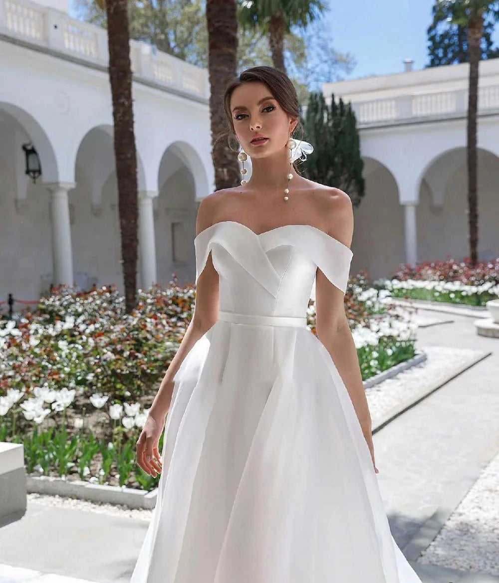 Elegant white organza A-line wedding dress with off-the-shoulder neckline, perfect for a modern bridal look