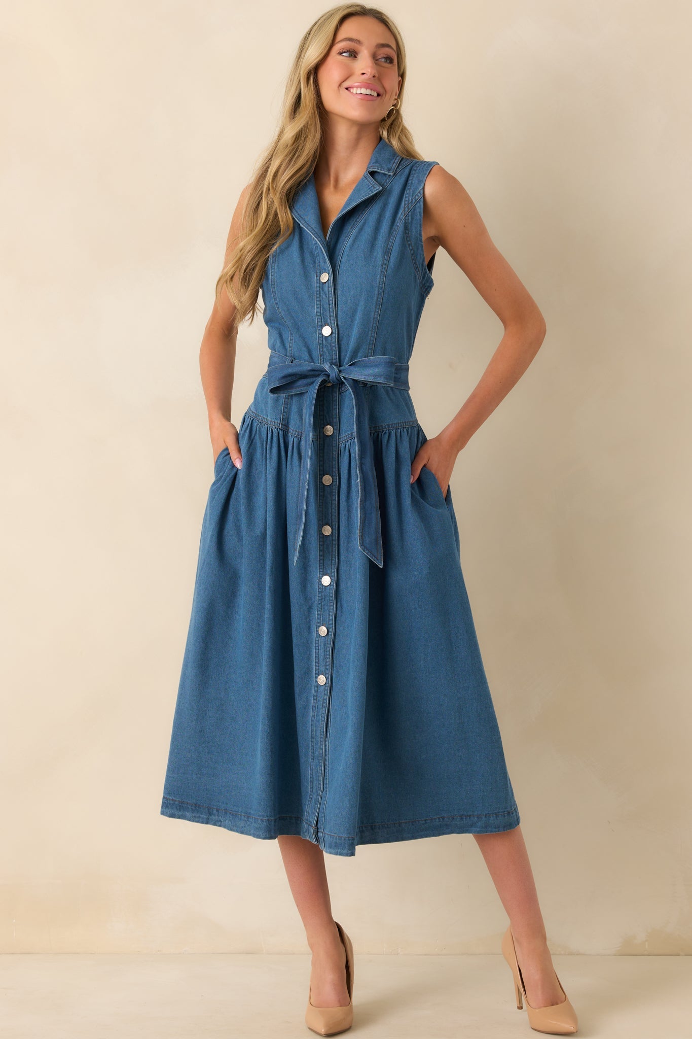 A full front view of the blue denim midi dress with a collared neckline, button front, and self-tie waistband.