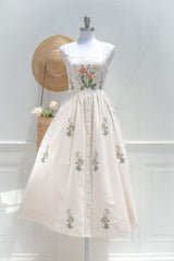 Cream cotton midi dress with floral embroidery on structured square neckline bodice and button front skirt front view.