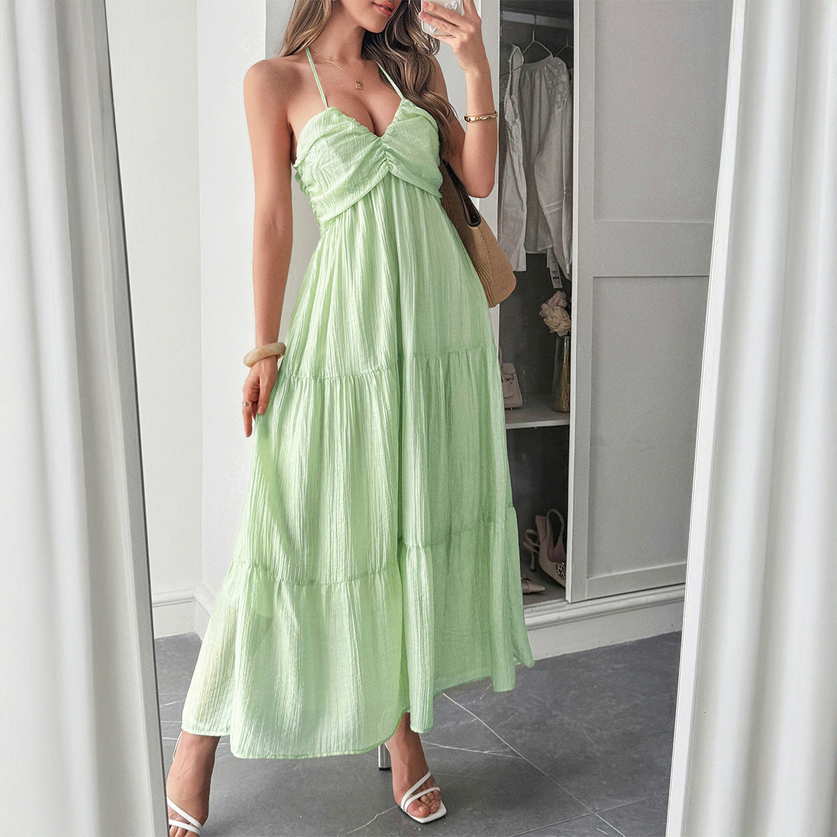 Woman wearing a flowy halterneck tiered maxi dress with ruffle details styled for a boho summer vacation look, vacation outfits, Summer beach maxi dress, summer fits, backless maxi dress, summer dresses, boho maxi, vacation dresses.