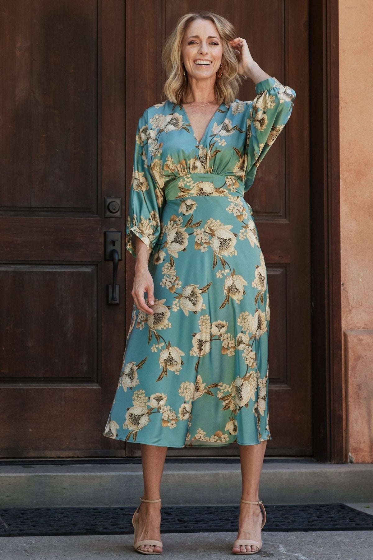 Front view of Joni Satin Midi Dress in blue multi floral print on model, V-neck, gathered bust, long batwing sleeves, midi hem (front).