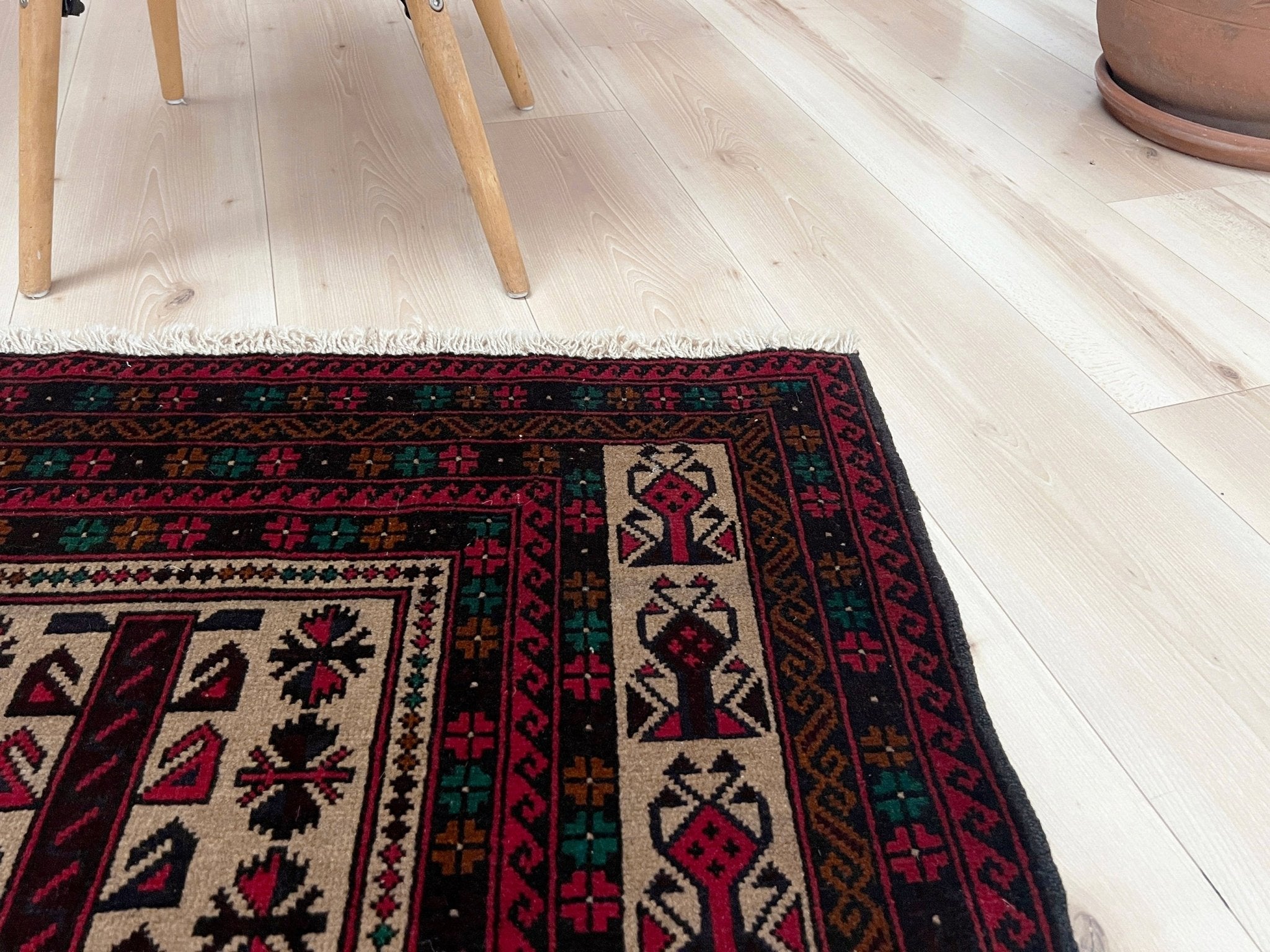 Corner picture of a Baluch Turkmen Prayer Rug - Handmade Wool Carpet in a 3x5 size, featuring traditional tribal geometric patterns with rich red, black, beige, green, and teal colors. Ideal for living room, bedroom, kitchen, entryway, or nursery decor. Available at a handmade rug shop in the San Francisco Bay Area.