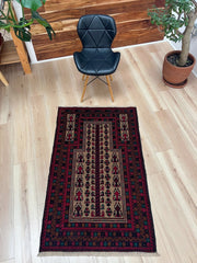 Real life picture of a Baluch Turkmen Prayer Rug - Handmade Wool Carpet in a 3x5 size, featuring traditional tribal geometric patterns with rich red, black, beige, green, and teal colors. Ideal for living room, bedroom, kitchen, entryway, or nursery decor. Available at a handmade rug shop in the San Francisco Bay Area.