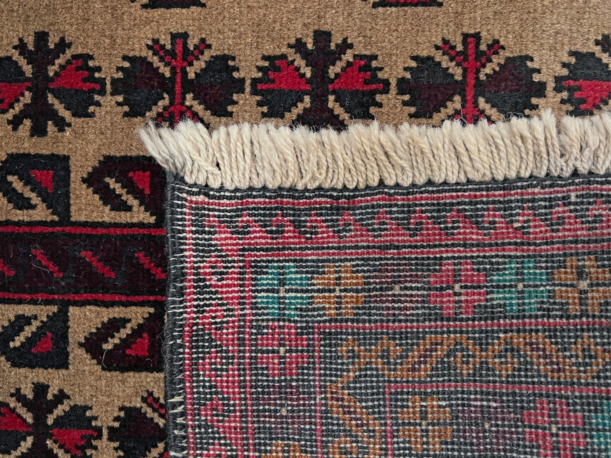 Back Detail of a Baluch Turkmen Prayer Rug - Handmade Wool Carpet in a 3x5 size, featuring traditional tribal geometric patterns with rich red, black, beige, green, and teal colors. Ideal for living room, bedroom, kitchen, entryway, or nursery decor. Available at a handmade rug shop in the San Francisco Bay Area.