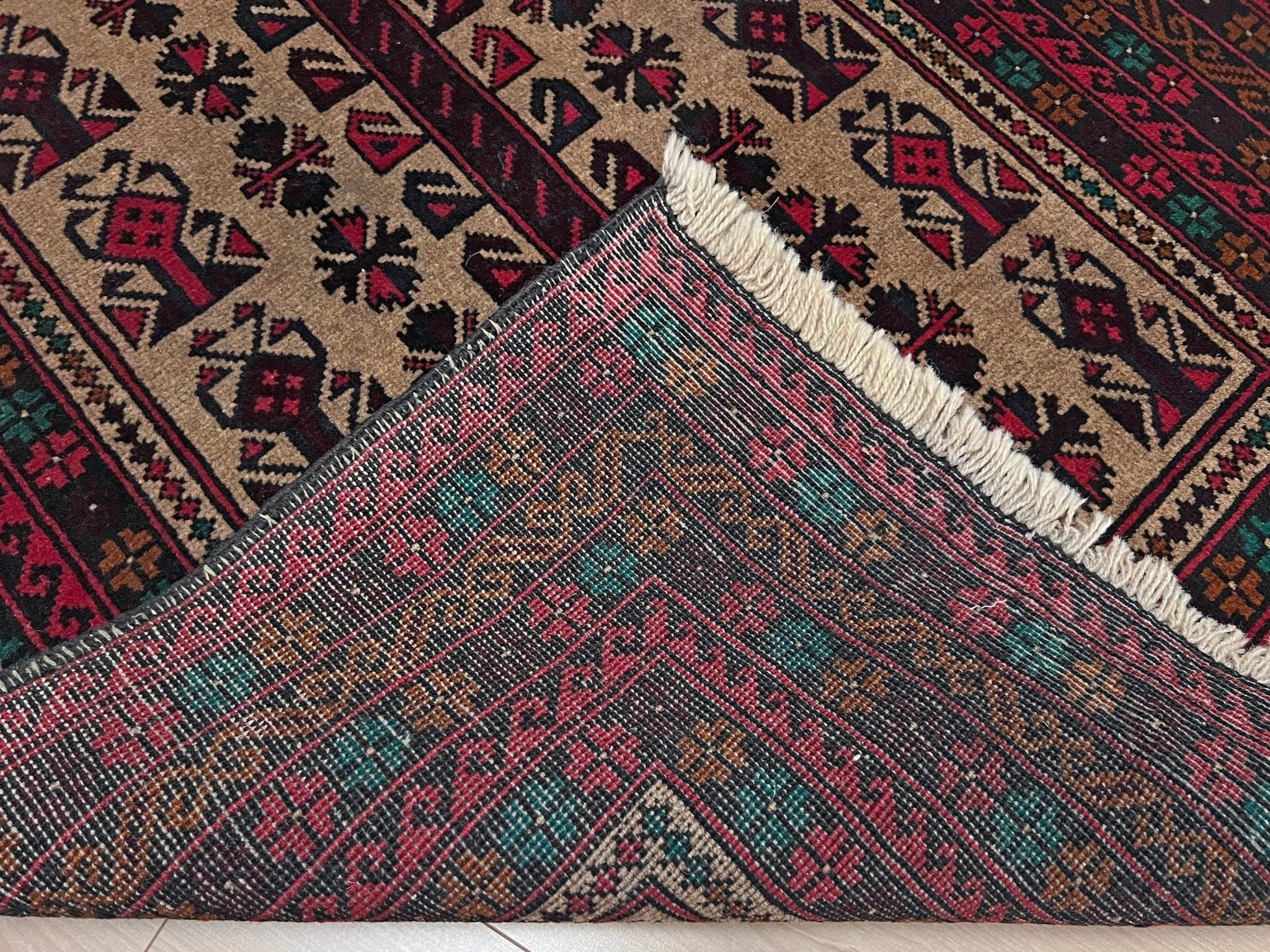 Back of a Baluch Turkmen Prayer Rug - Handmade Wool Carpet in a 3x5 size, featuring traditional tribal geometric patterns with rich red, black, beige, green, and teal colors. Ideal for living room, bedroom, kitchen, entryway, or nursery decor. Available at a handmade rug shop in the San Francisco Bay Area.