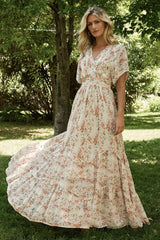 Cream and rust floral maxi dress, front view showing surplice neckline, flutter sleeves, and angled tiered skirt for movement.