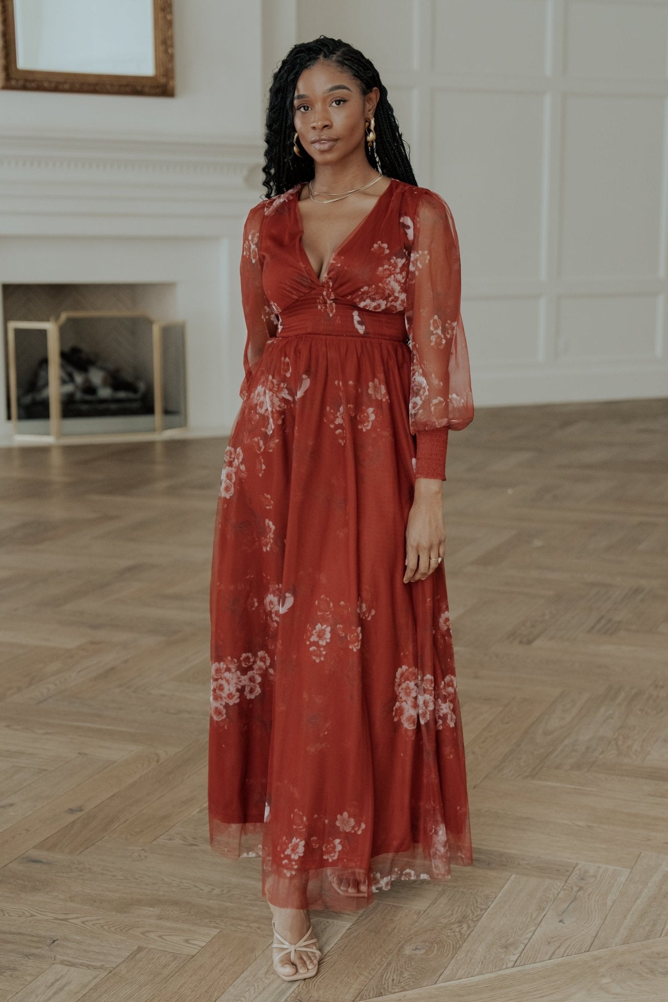 Full-length front view of the Layla tulle maxi dress in rust floral with deep V-neck, smocked waist and flowing layered skirt, model pose.