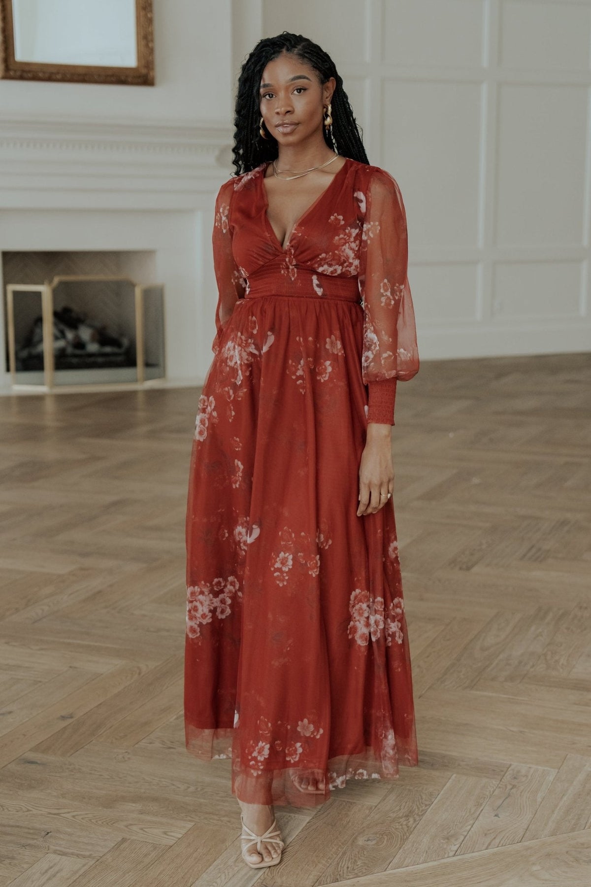 Full-length front view of the Layla tulle maxi dress in rust floral with deep V-neck, smocked waist and flowing layered skirt, model pose.