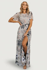 Front view of Naomi pale blue floral chiffon maxi dress on model, showing short flutter sleeves and removable waist tie for a feminine silhouette.