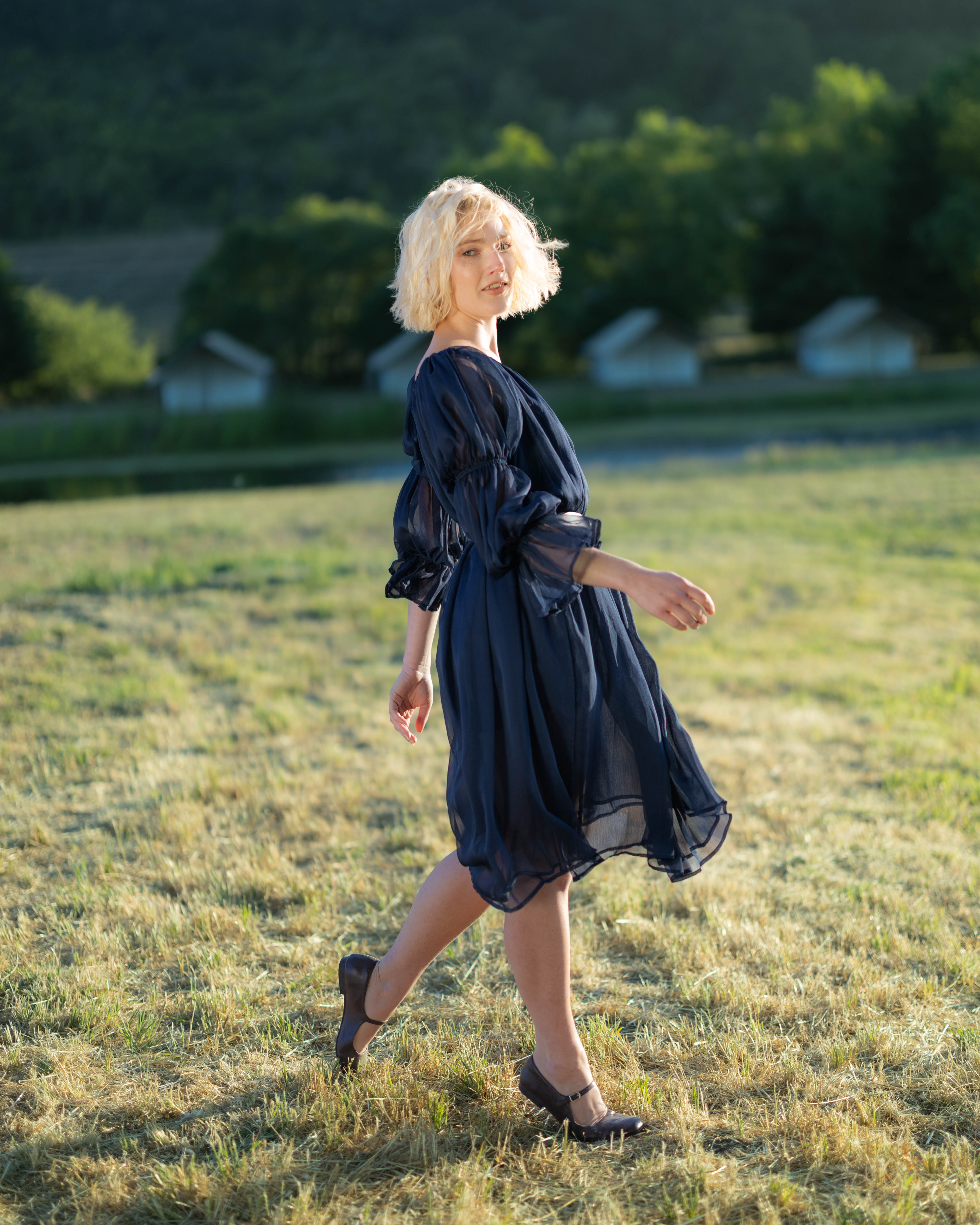 Woman walking outdoors wearing a Navy Blue Chiffon Chemise with puff sleeves and flowing silhouette
