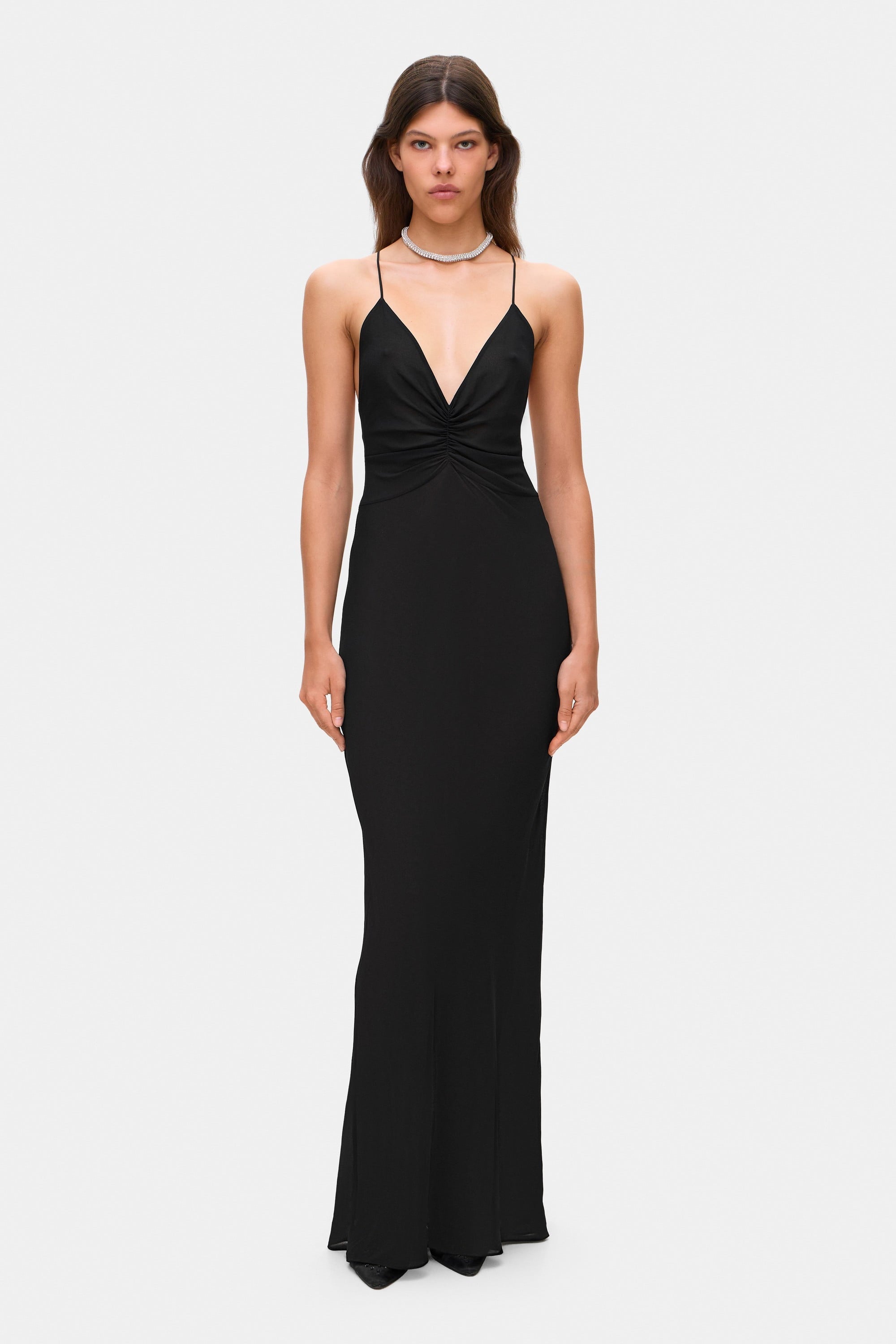 Woman wearing a black Eliana dress on a white background, front view