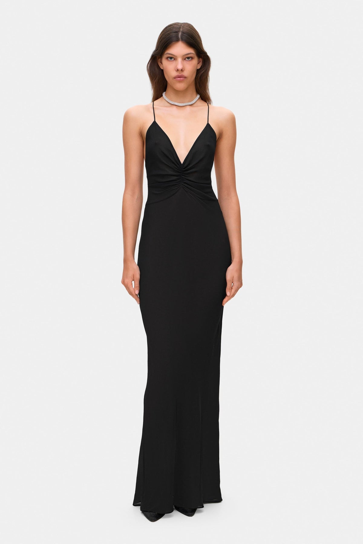 Woman wearing a black Eliana dress on a white background, front view