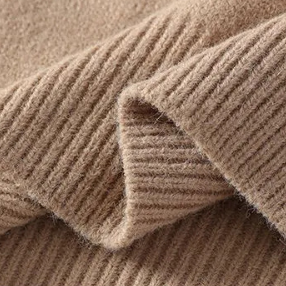 Beige ribbestrikket ullstoff, nærbilde. Myk tekstur, høy kvalitet, perfekt for vinterklær og strikkede plagg.