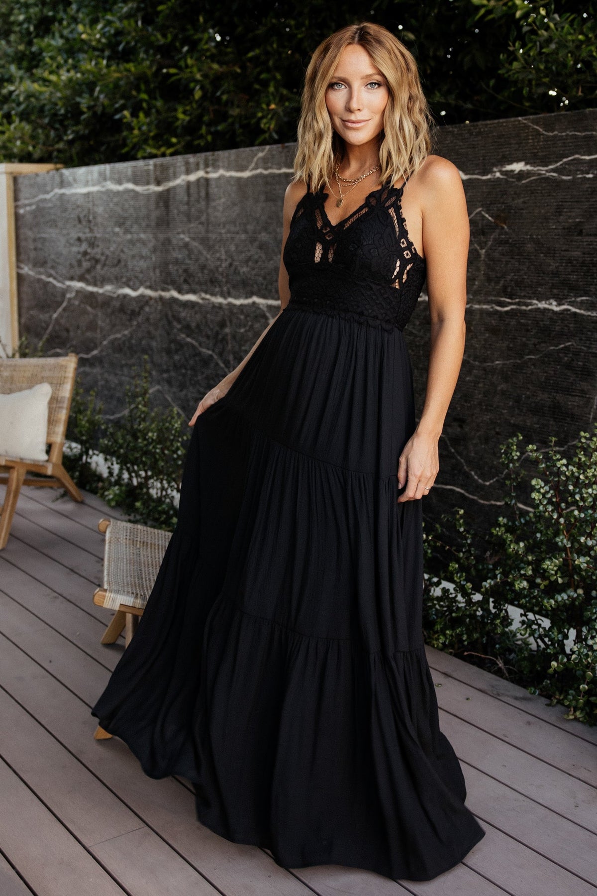 Front view of black tiered maxi dress with lace bodice, adjustable double criss-cross straps, and fully lined lightweight woven fabric for warm-weather wear.