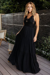 Front view of black tiered maxi dress with lace bodice, adjustable double criss-cross straps, and fully lined lightweight woven fabric for warm-weather wear.